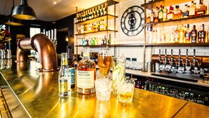 A bar area with a copper pipe, bottles of liquor, and glasses on the counter. - Avon Gorge by Hotel du Vin (Bristol)