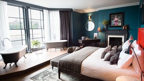 A modern bedroom with a large bed, a clawfoot bathtub, a desk, and a fireplace. - Avon Gorge by Hotel du Vin (Bristol)