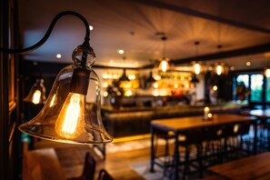 A bar area with hanging light fixtures and a bar counter. - Avon Gorge by Hotel du Vin (Bristol)