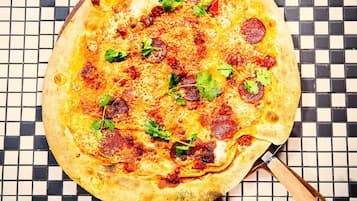 En pizza på en skakternet flisetæppe.