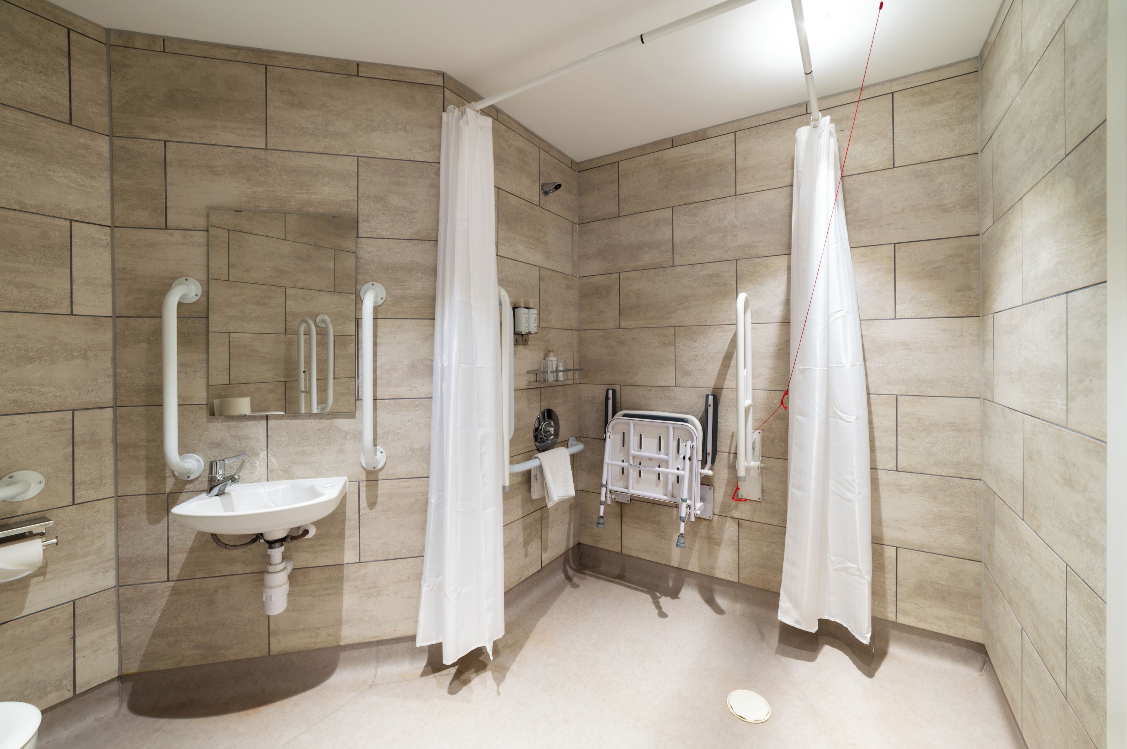 A modern bathroom with a sink, toilet, and shower area.