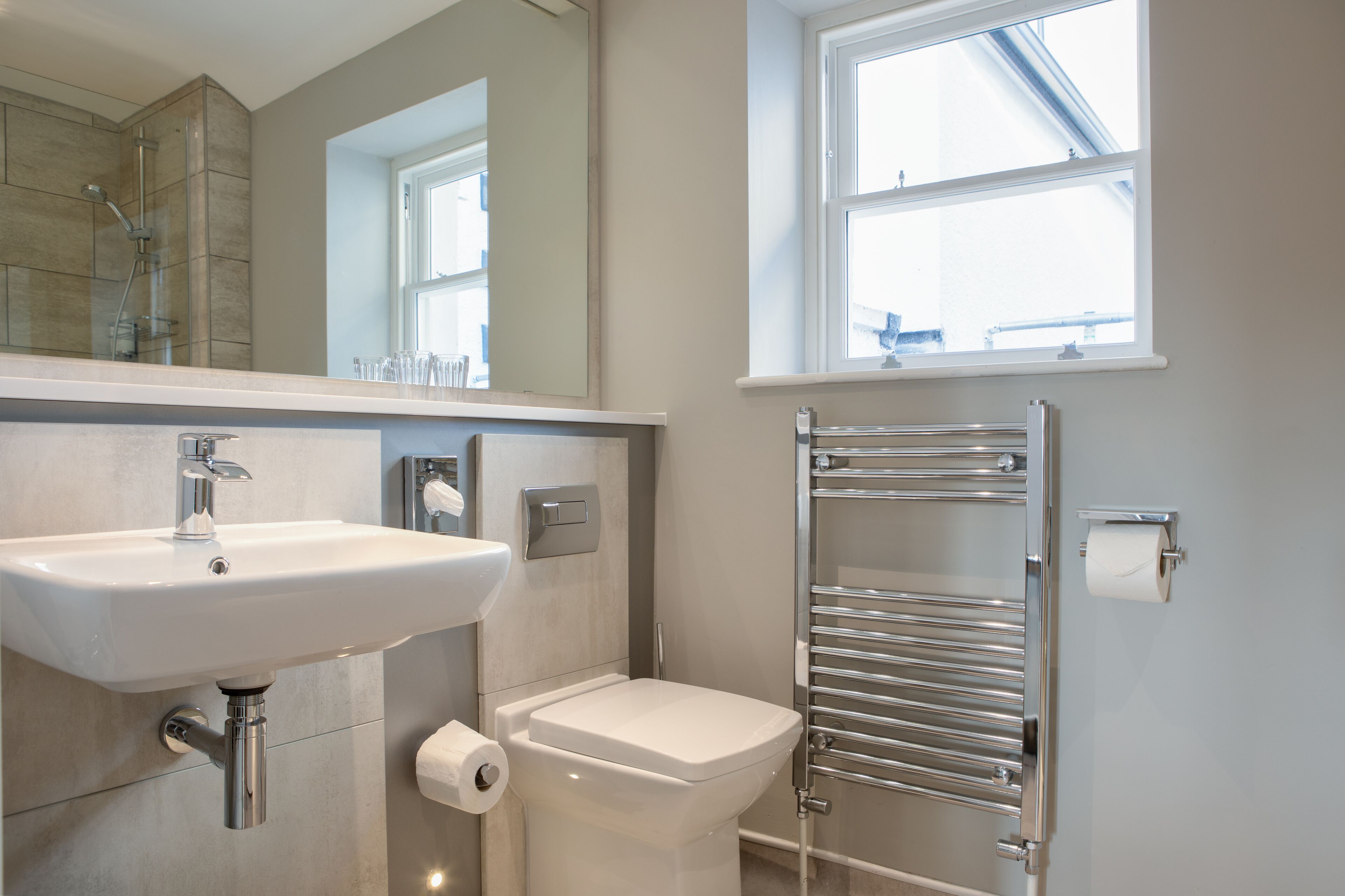 Un baño moderno con lavamanos, inodoro y toallero.