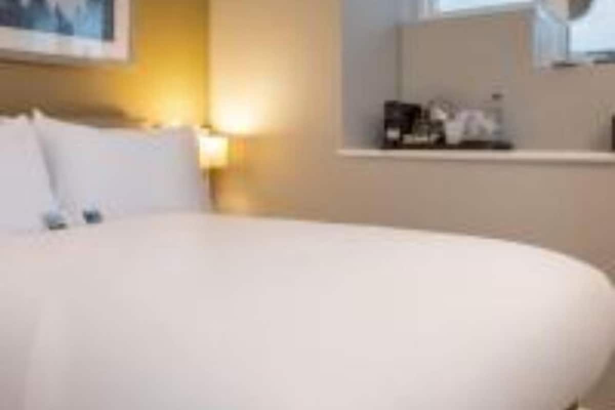 Ropa de cama hipoalergénica y caja de seguridad en la habitación