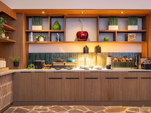Une cuisine moderne avec des meubles en bois, un pare-feu en pierre et une variété d’appareils de cuisine et d’éléments de décoration.