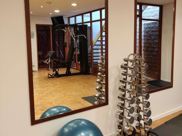 A gym with exercise equipment, a mirror, and exercise balls. - Mercure Brussels Centre Rogier (Brussels)