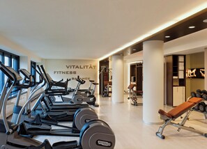 A gym with cardio machines, weightlifting equipment, and a wall with 'VITALITÄT FITNESS' text. - Estrel Hotel Berlin (Berlin)
