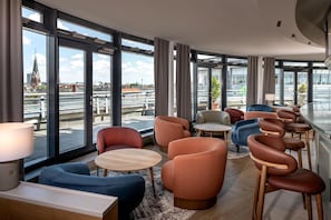 A modern hotel lobby with large windows, seating areas, and a view of the cityscape. - Radisson Hotel Berlin Charlottenburg (Berlin)