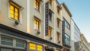 Un hotel de varios pisos, con amplias ventanas y una entrada bien iluminada.