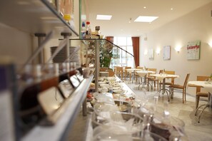 Una mesa de buffet con diversos alimentos y utensilios.