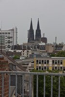 Un paisaje urbano con edificios modernos y una catedral histórica con dos torres gemelas.
