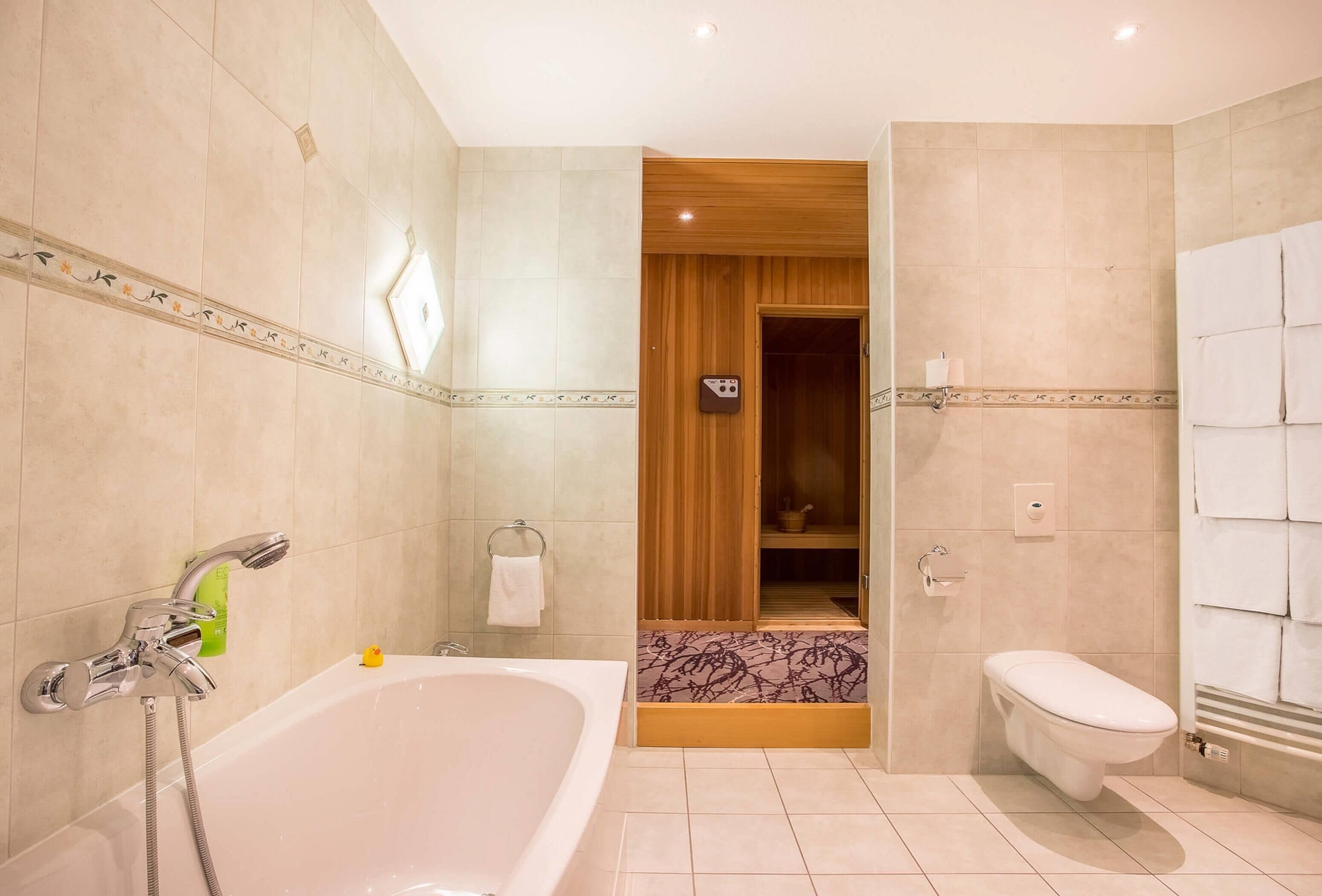 A modern bathroom with a bathtub, toilet, and shower.