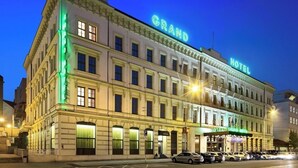 Un edificio storico di un hotel dallo stile architettonico classico, con un evidente cartello con la scritta "GRAND HOTEL" sulla facciata.