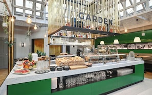 A buffet setup with a variety of food items and a bar area with bottles and glasses. - Grandhotel Brno (Brno)
