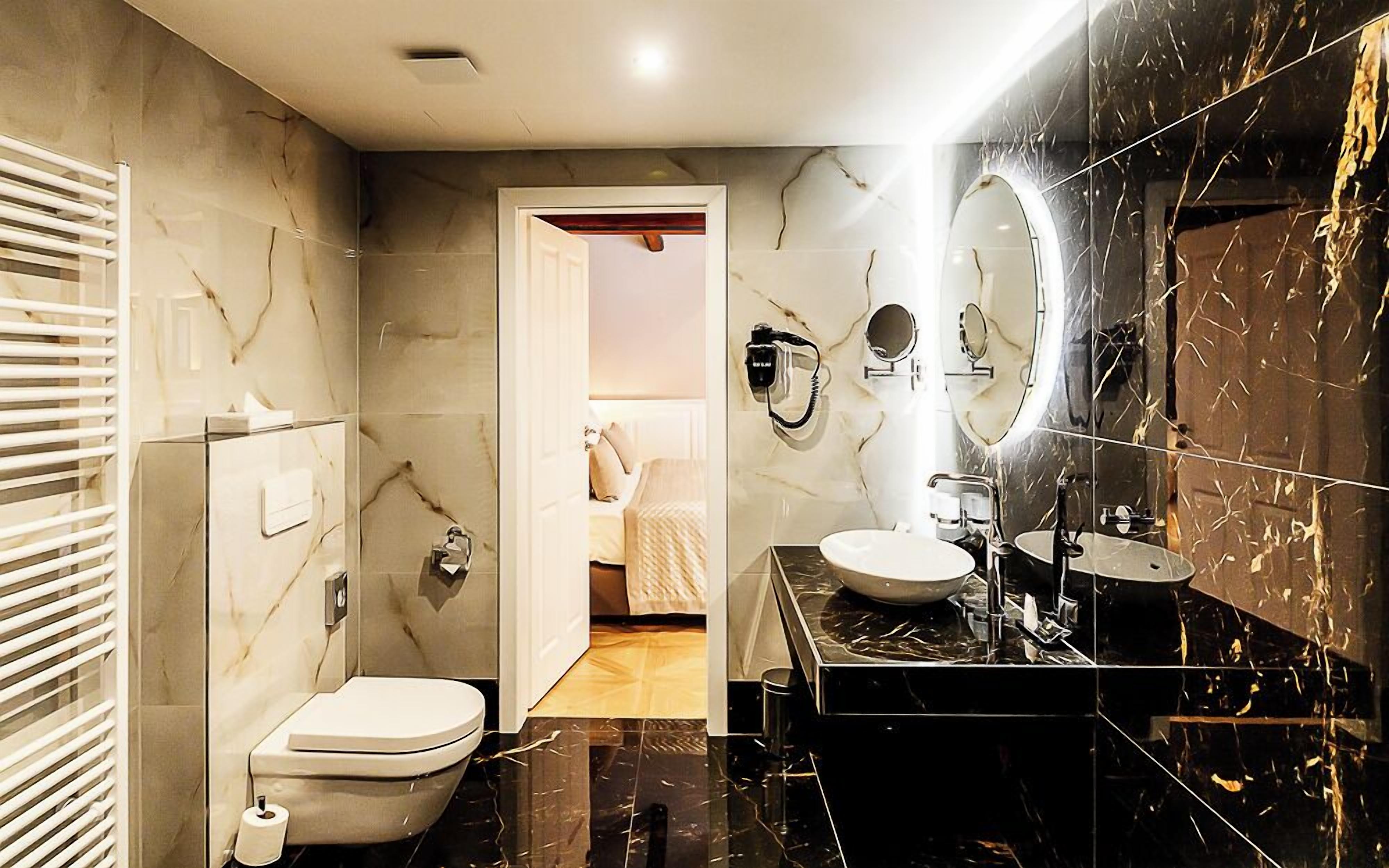 A modern bathroom with a toilet, bidet, and a large mirror.