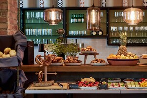 Un bufé con diferentes opciones de comida y una zona de bar con botellas y vasos.