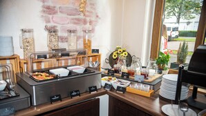 Una mesa de buffet con distintos alimentos y aderezos.