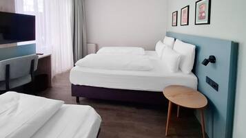 Une chambre d’hôtel avec un lit, un bureau, une chaise, une télévision et une petite table.