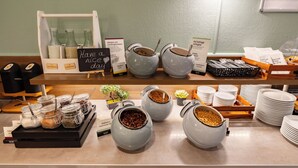 Un bufé de desayuno con diversos alimentos y recipientes.