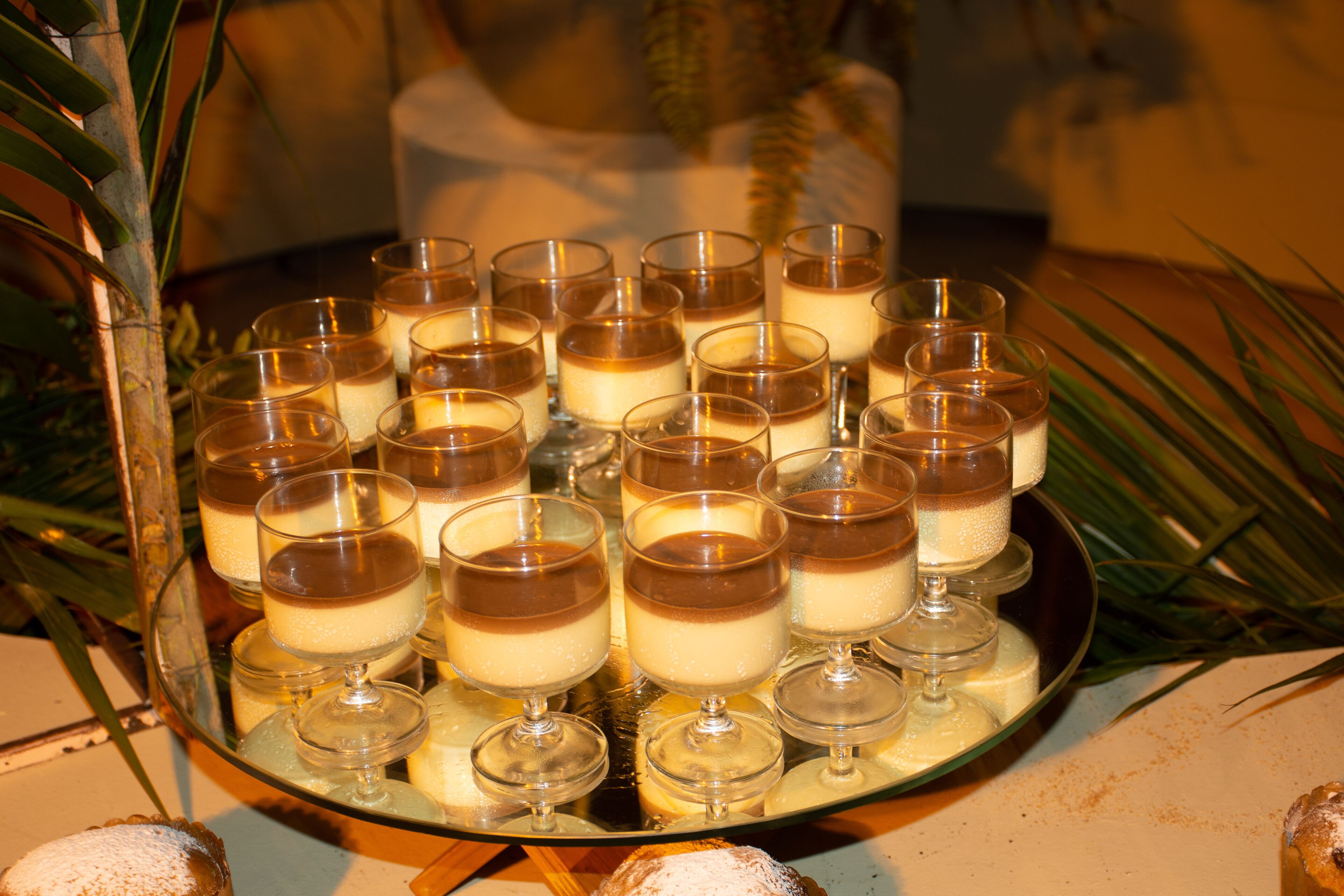 A tray of dessert cups arranged on a reflective surface.