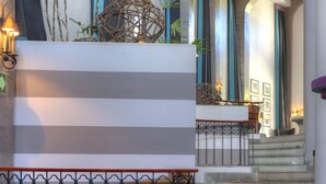A staircase with a railing, a wall with a striped pattern, and some plants. - Alta Las Palomas Hotel  (Santa Ana)