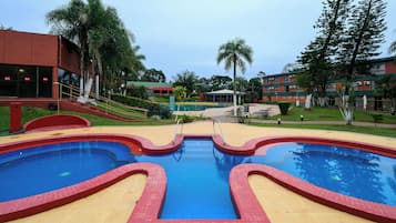 Relax by the resort pool surrounded by lush landscaping.