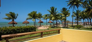 Guests can relax on the resort's lawn, surrounded by ocean views and shaded areas.
