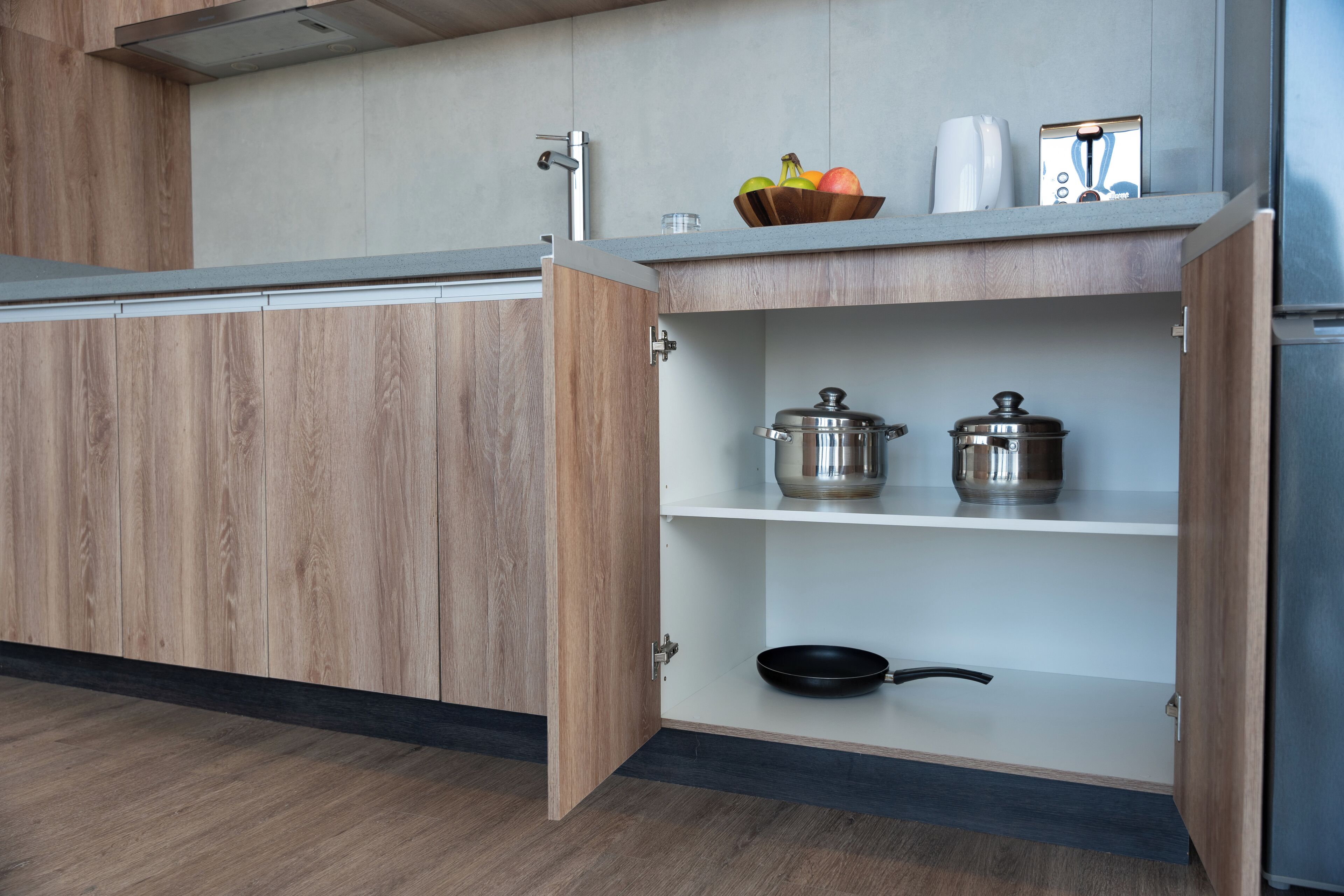 Una cocina moderna con armarios de madera, una encimera y una repisa empotrada con utensilios de cocina.