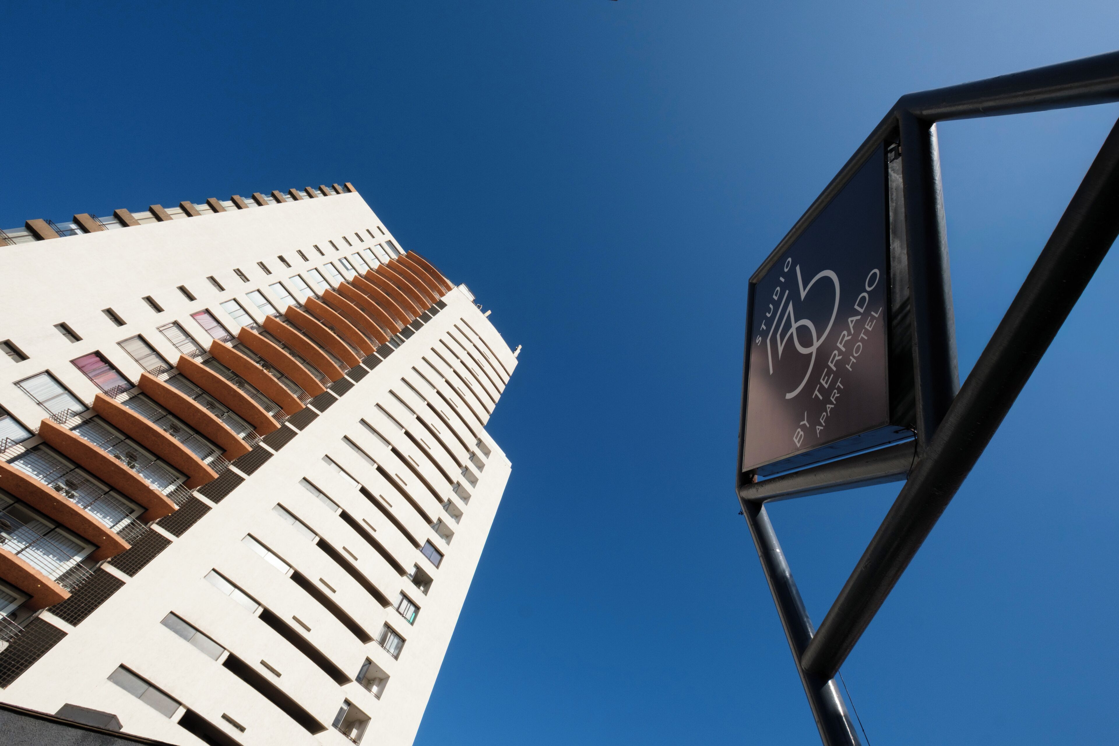 A tall building with a modern design, featuring a prominent sign for a hotel.
