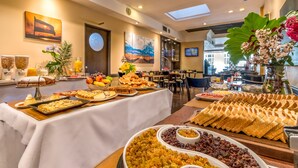 A buffet with various food items and a large painting on the wall. - Up Viamonte Hotel (Buenos Aires)