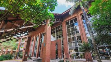 Un edificio con grandes ventanales, fachada de ladrillo y un área de entrada techada.