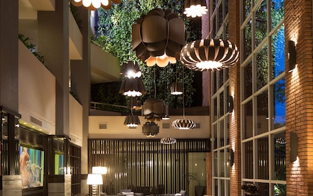 A spacious lobby with high ceilings, modern furniture, and large windows allowing natural light.