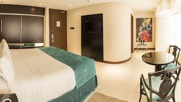 Een hotelkamer met een bed, een bureau, een stoel, een televisie en een schilderij.
