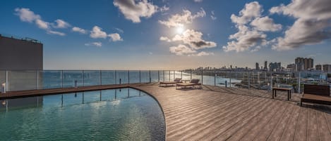 Una piscina al aire libre, sillones reclinables de piscina