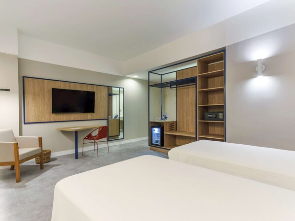 Relax in a spacious room with a large bed, desk, and flat-screen TV.