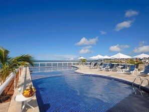 Relax by the pool with a refreshing drink and a view of the city skyline.
