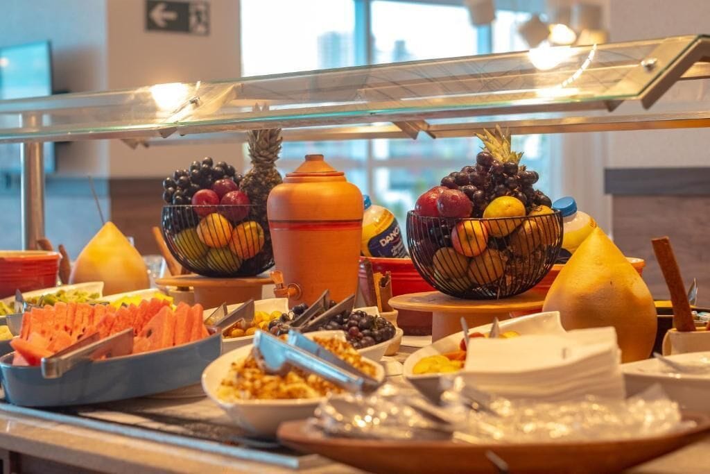 Un bufé con diversos alimentos y un cuenco de fruta.