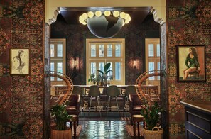 A traditional interior with patterned walls, a dining area with chairs and a table, and a large globe chandelier. - Graduate by Hilton Berkeley (Berkeley)
