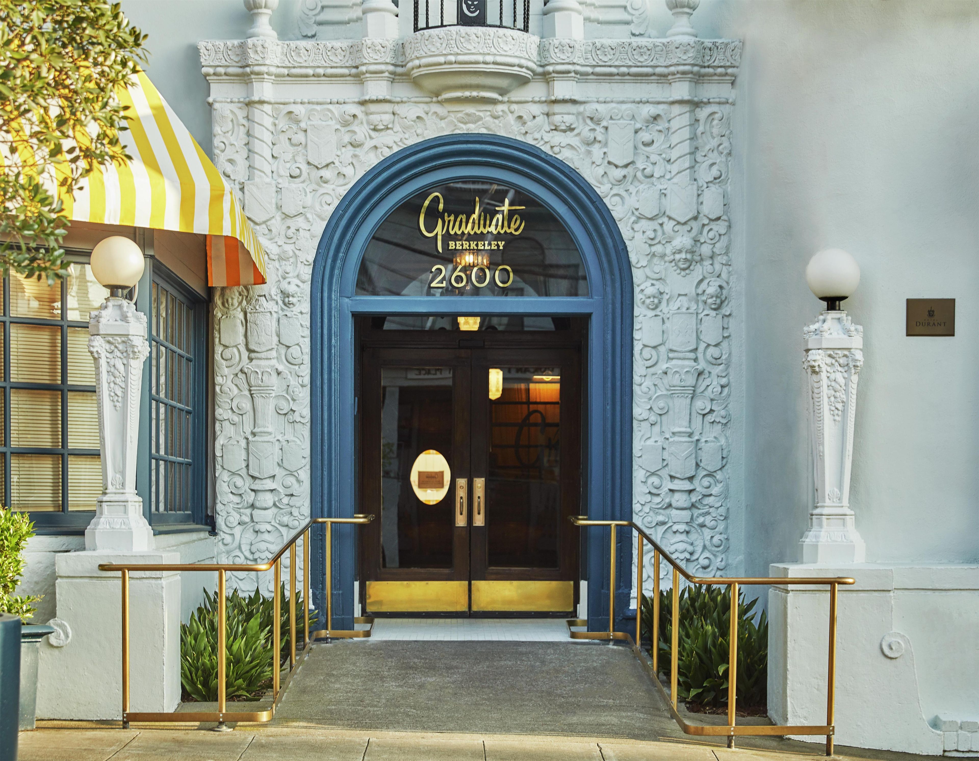 A building entrance with a blue archway, a sign reading 'Graduate Berkeley 2600', and a 'Durant' sign on the wall.