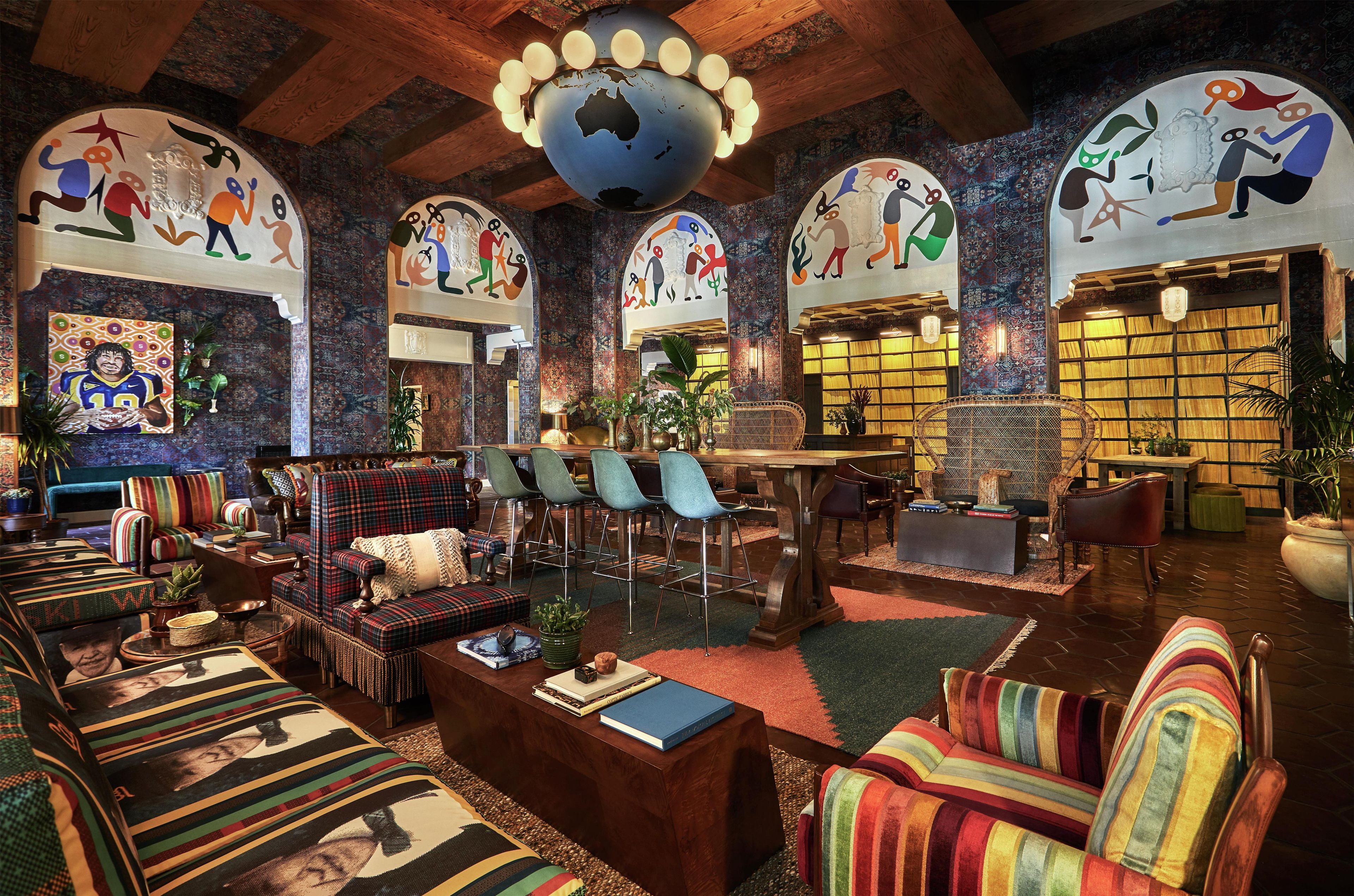 A cozy lounge area with striped sofas, a wooden coffee table, and a large globe hanging from the ceiling.