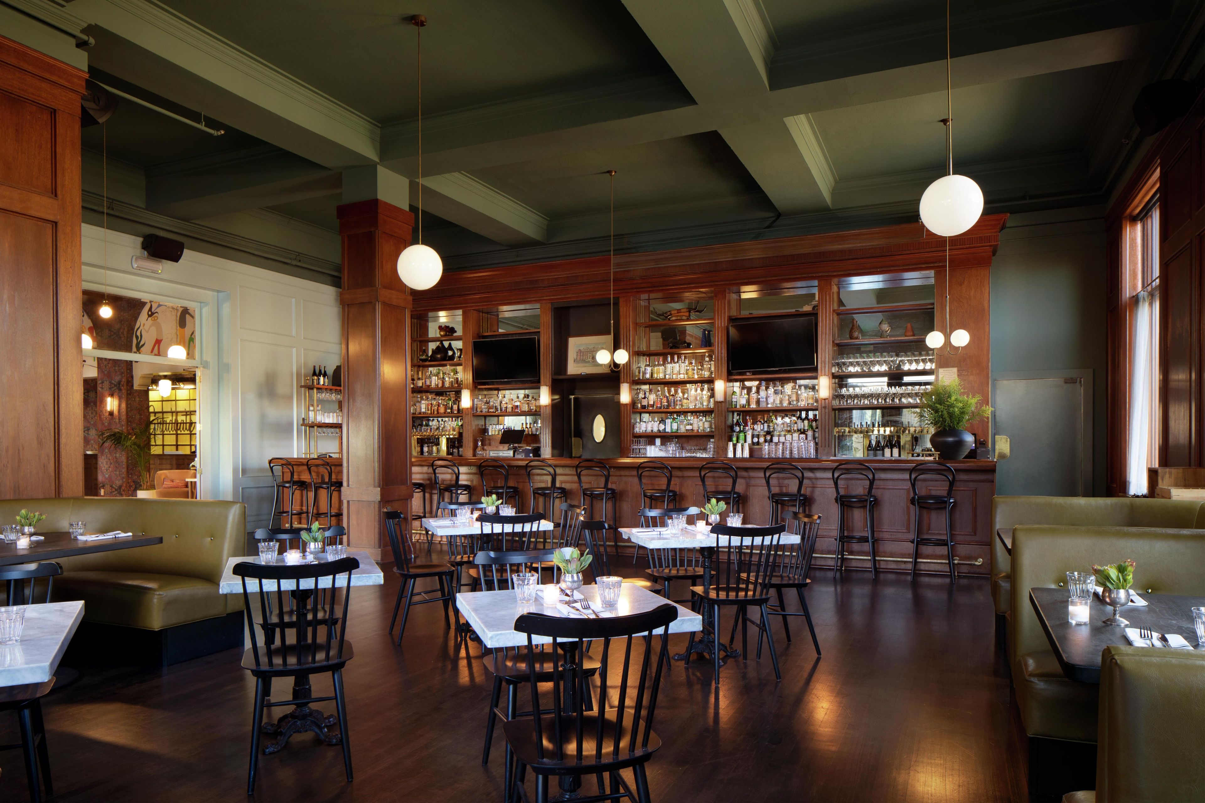 A restaurant interior with booths, tables, and a bar area.