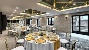 A banquet hall with round tables set for dining, featuring gold and white table settings. - The Insignia Hotel, Sarnia, a Tribute Portfolio Hotel (Sarnia)