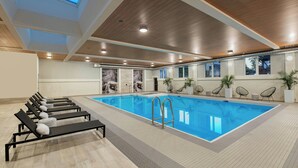 An indoor swimming pool with lounge chairs, a wooden ceiling, and potted plants. - The Insignia Hotel, Sarnia, a Tribute Portfolio Hotel (Sarnia)
