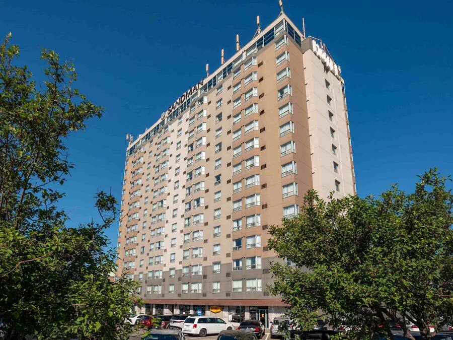 Un hotel alto de varios pisos con fachada uniforme y numerosas ventanas.