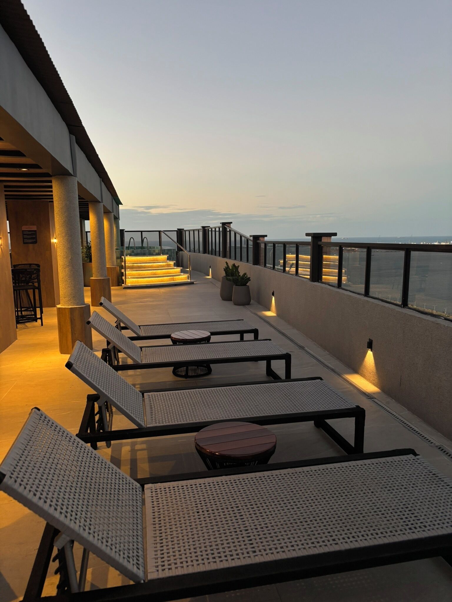 A terrace with outdoor seating and a view of the sea.
