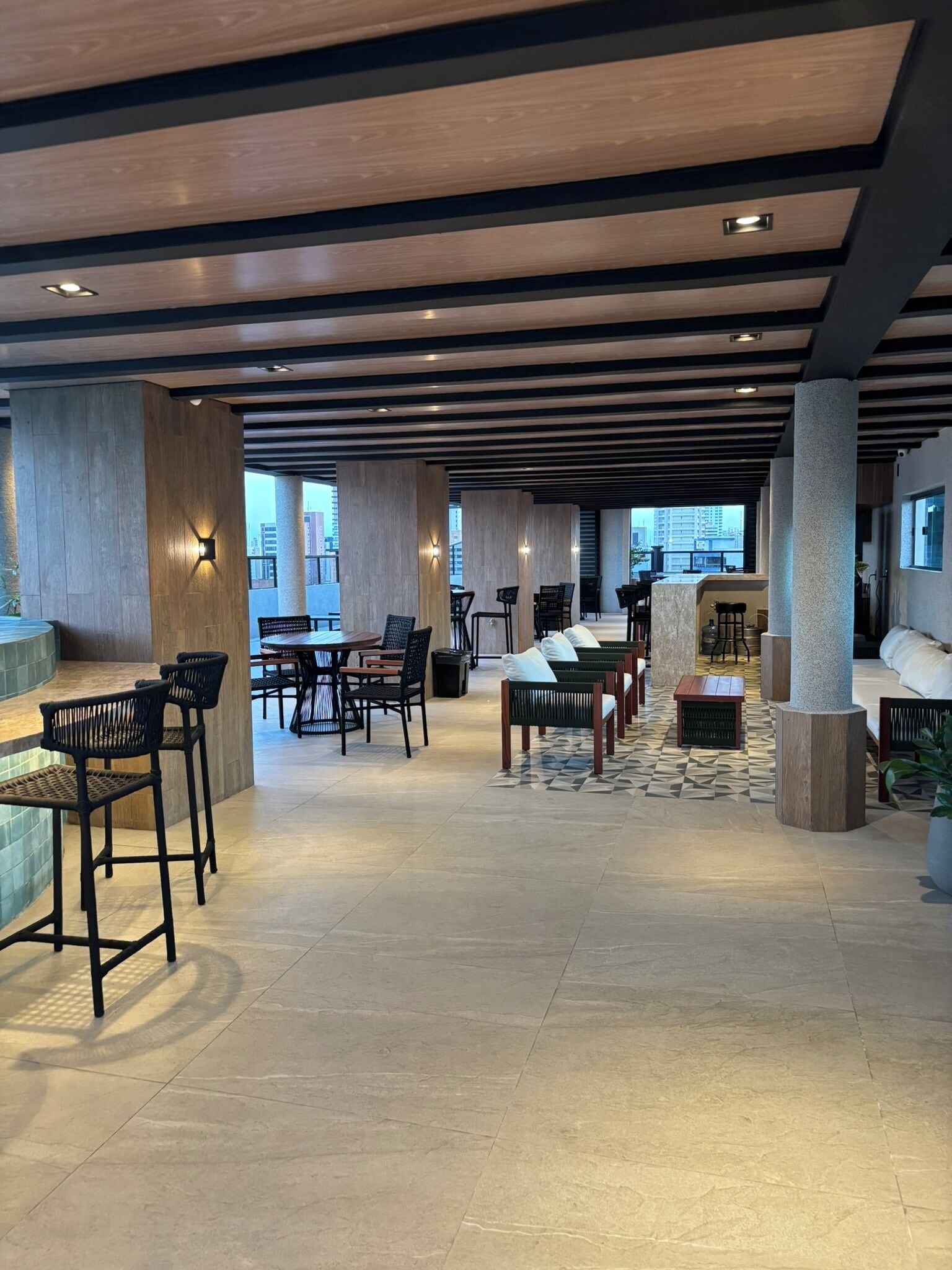 A spacious lobby with high ceilings, modern furniture, and large windows offering views of the city.