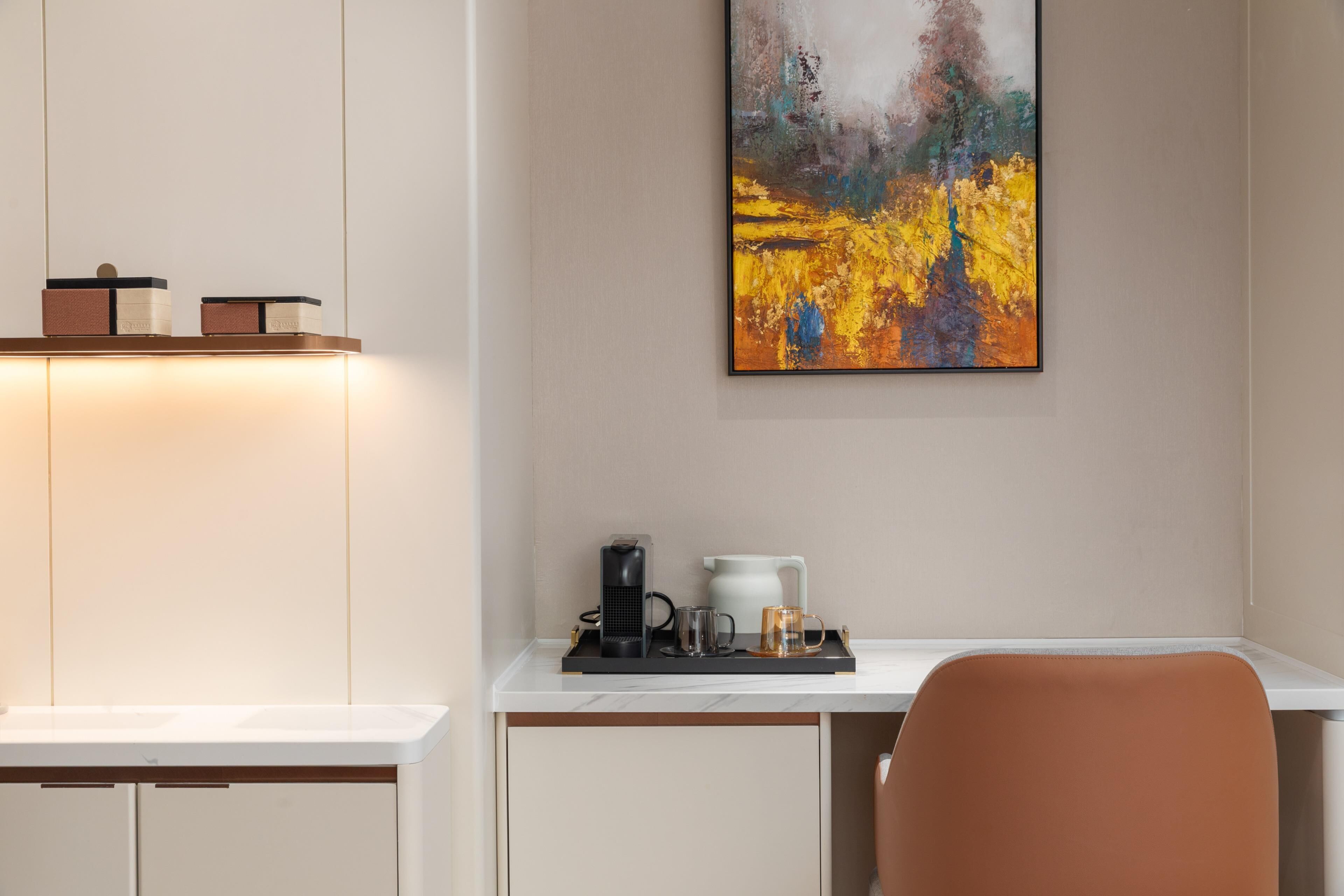 Een moderne kamer met een bureau, een koffiezetapparaat, een mok en een dienblad.