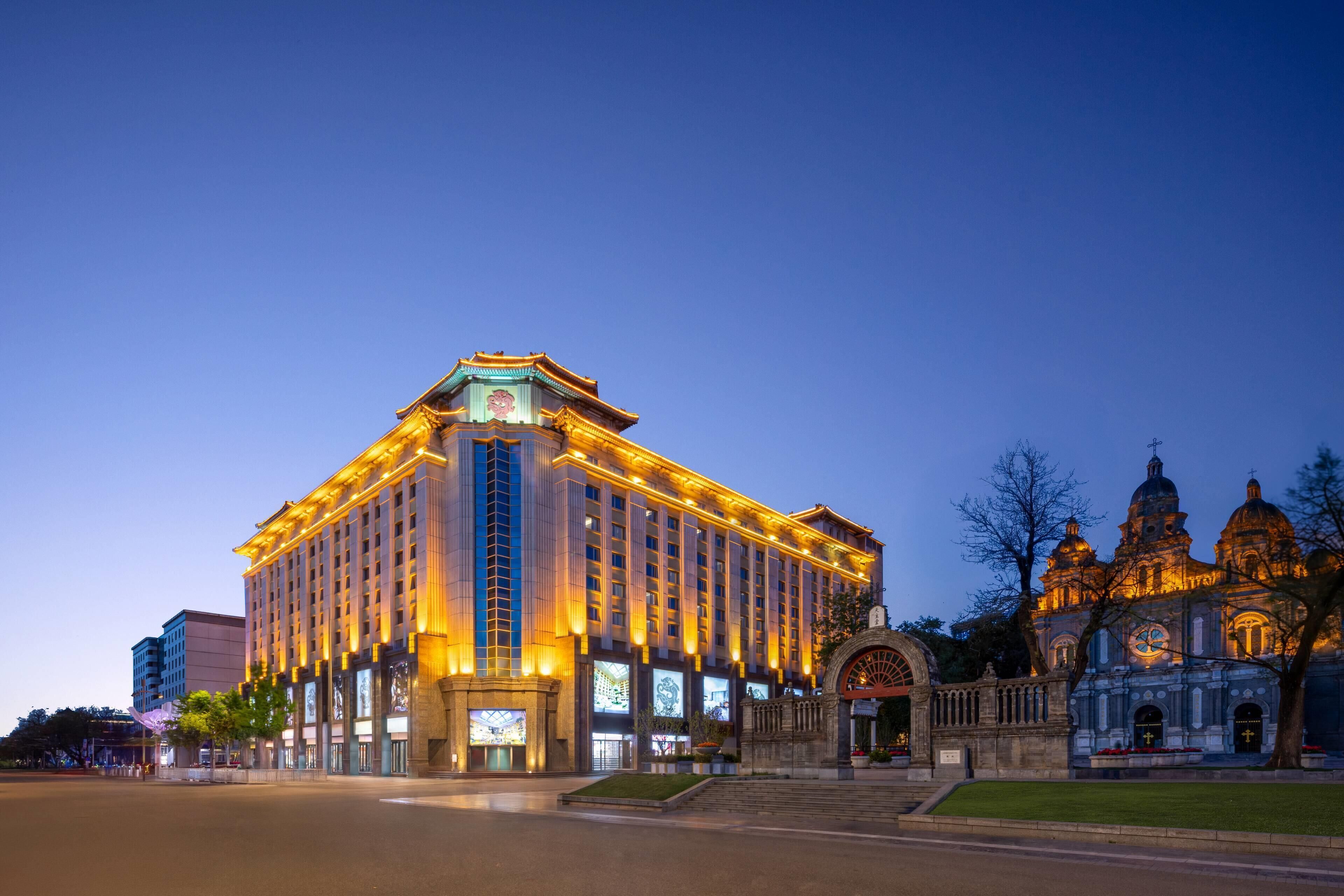 Um hotel grande, com vários andares, uma entrada imponente e uma fachada grandiosa.