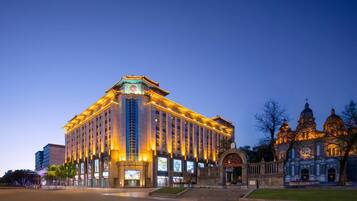Um hotel grande, com vários andares, uma entrada imponente e uma fachada grandiosa.