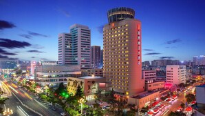 A high-rise hotel with multiple floors, surrounded by a busy urban street with visible traffic and streetlights. - Kunming Jin Jiang Hotel (Kunming)