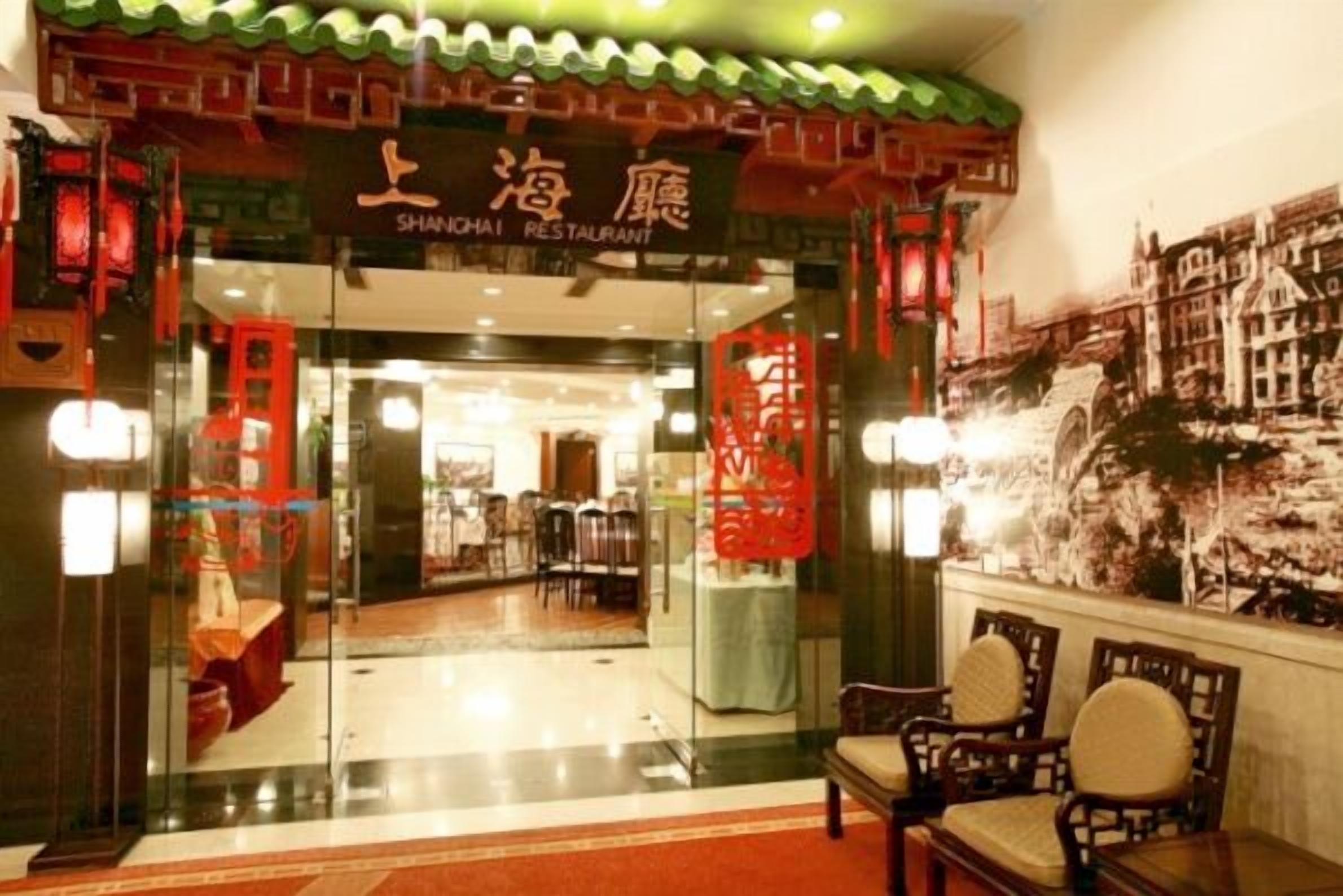 A restaurant with a traditional Chinese architectural entrance, featuring red lanterns and a signboard.